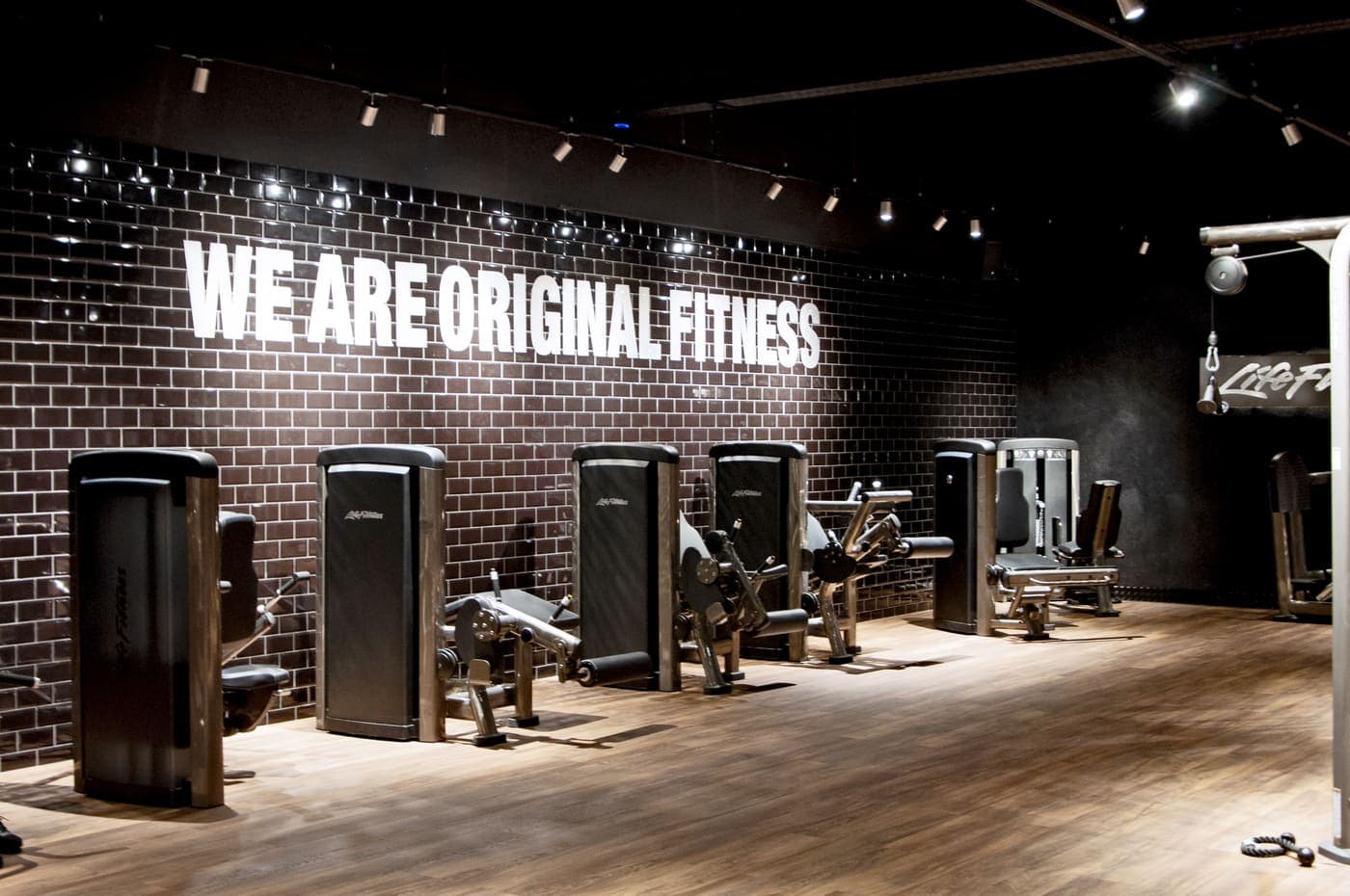 Mur « We are original fitness » et zone de training