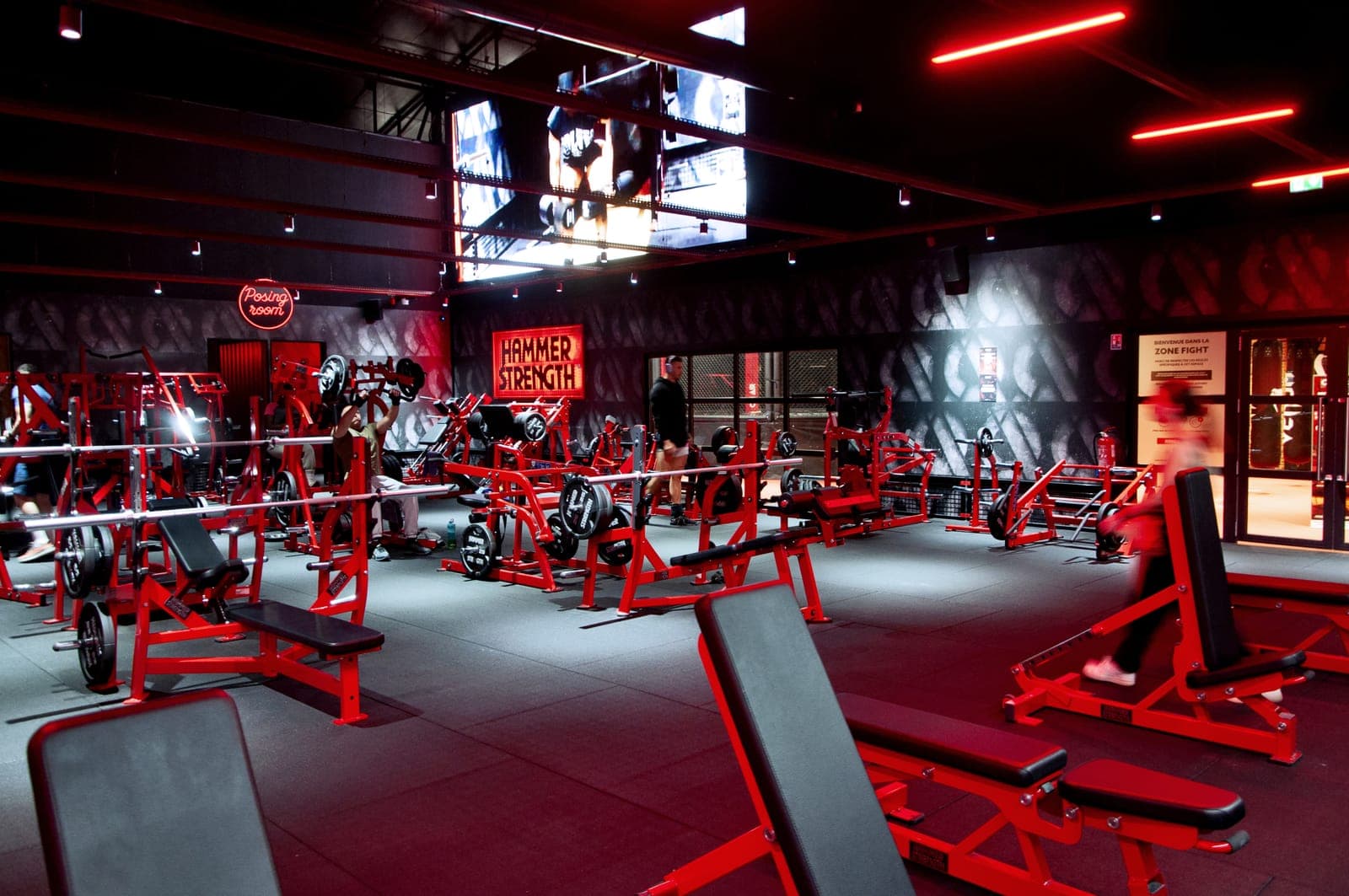 Plateau de musculation ON AIR aux machines rouges sous éclairage rouge, dans un ancien garage transformé en salle de sport à Décines-Charpieu