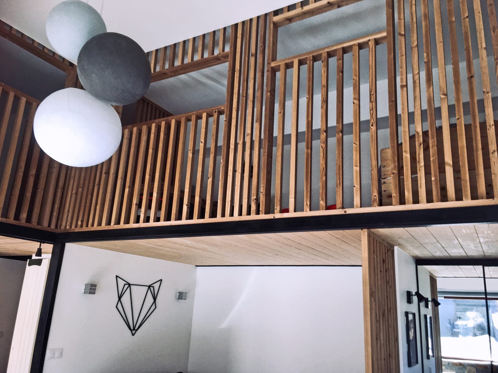 Mezzanine à garde-corps en claire-voie bois au-dessus d'un séjour toute hauteur, dans un duplex aux Allues