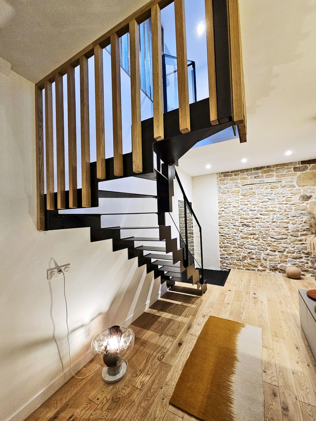 Escalier bois suspendu le long d'un mur de pierre