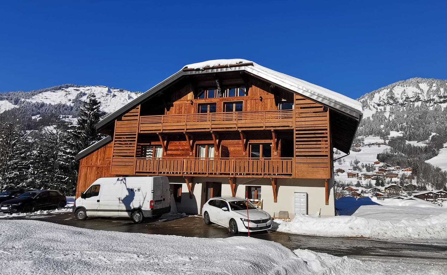 Grand chalet savoyard en bois sous la neige, ancienne ferme réhabilitée en appartements à Praz-sur-Arly