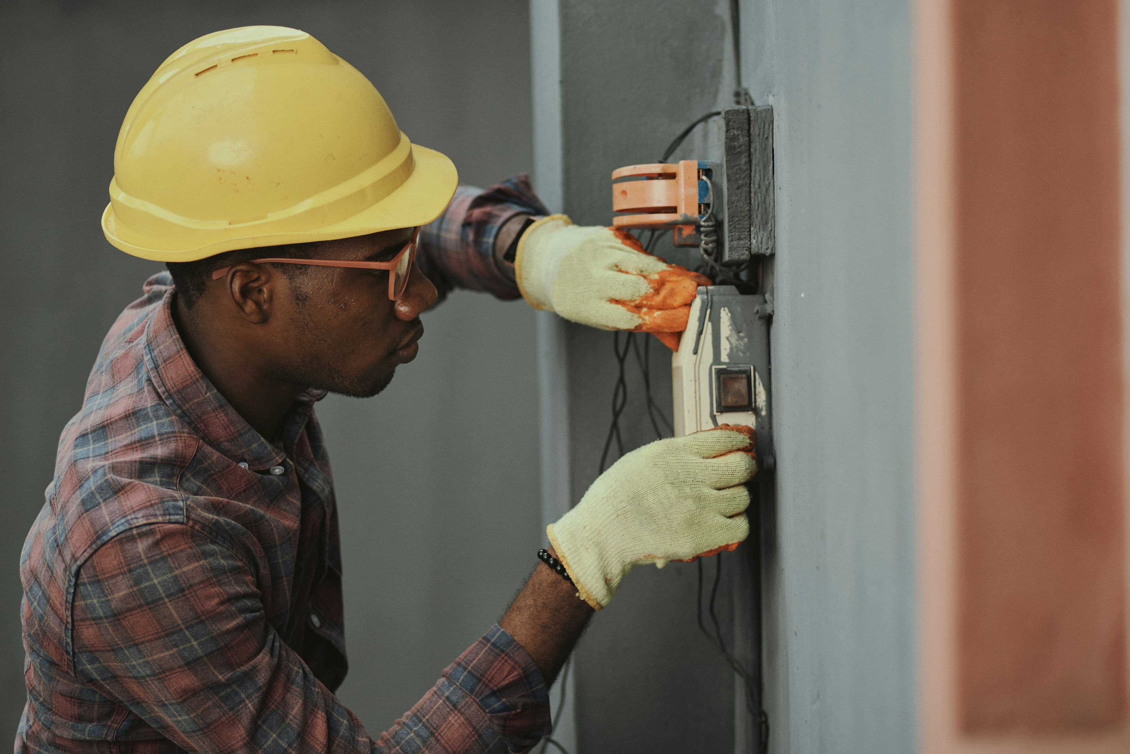Électricien en casque installant le câblage d'un tableau