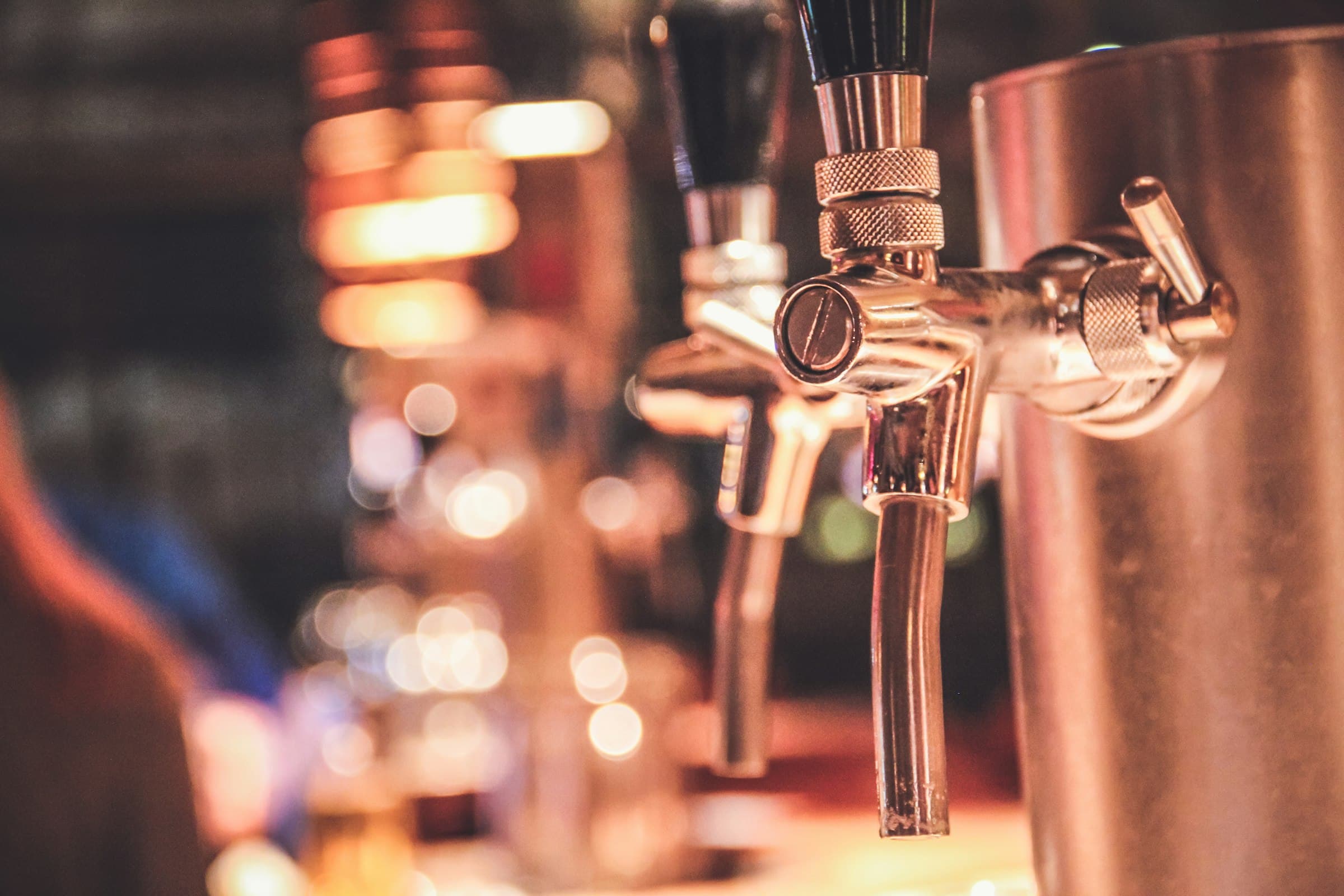 Tireuses à bière en laiton sous une lumière chaude