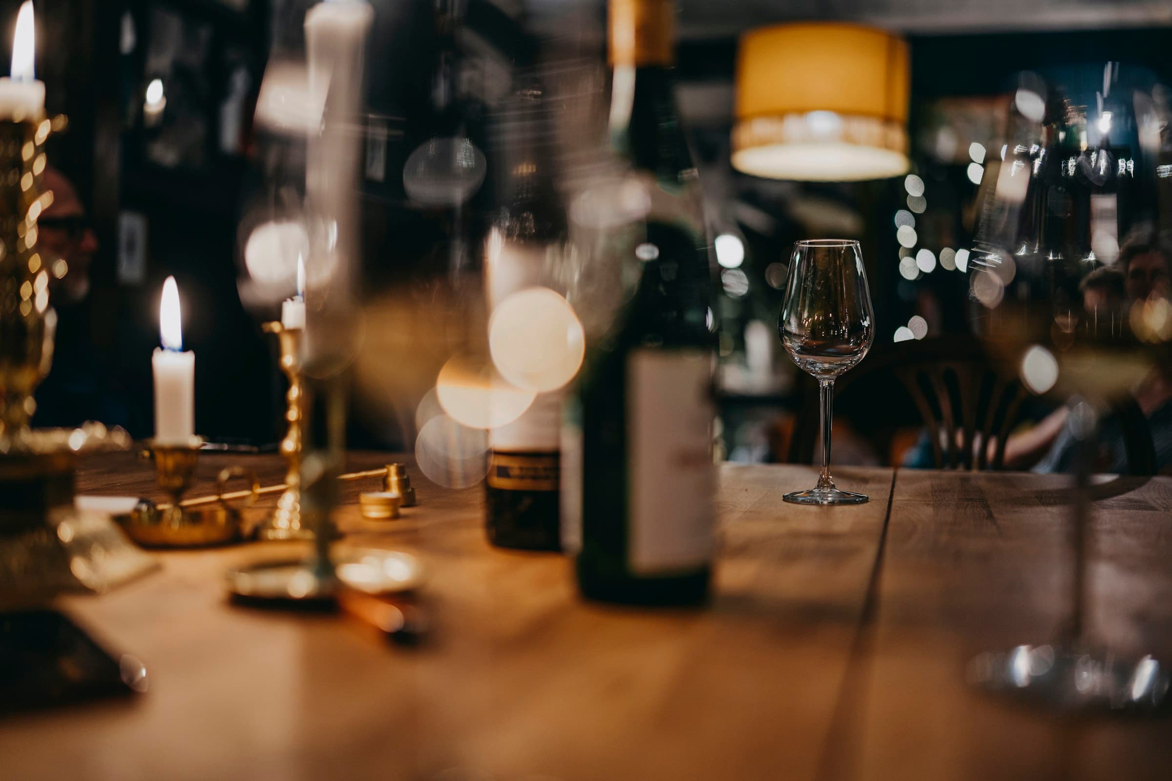 Bar à vin à la bougie, bouteille et verre sur une table de bois