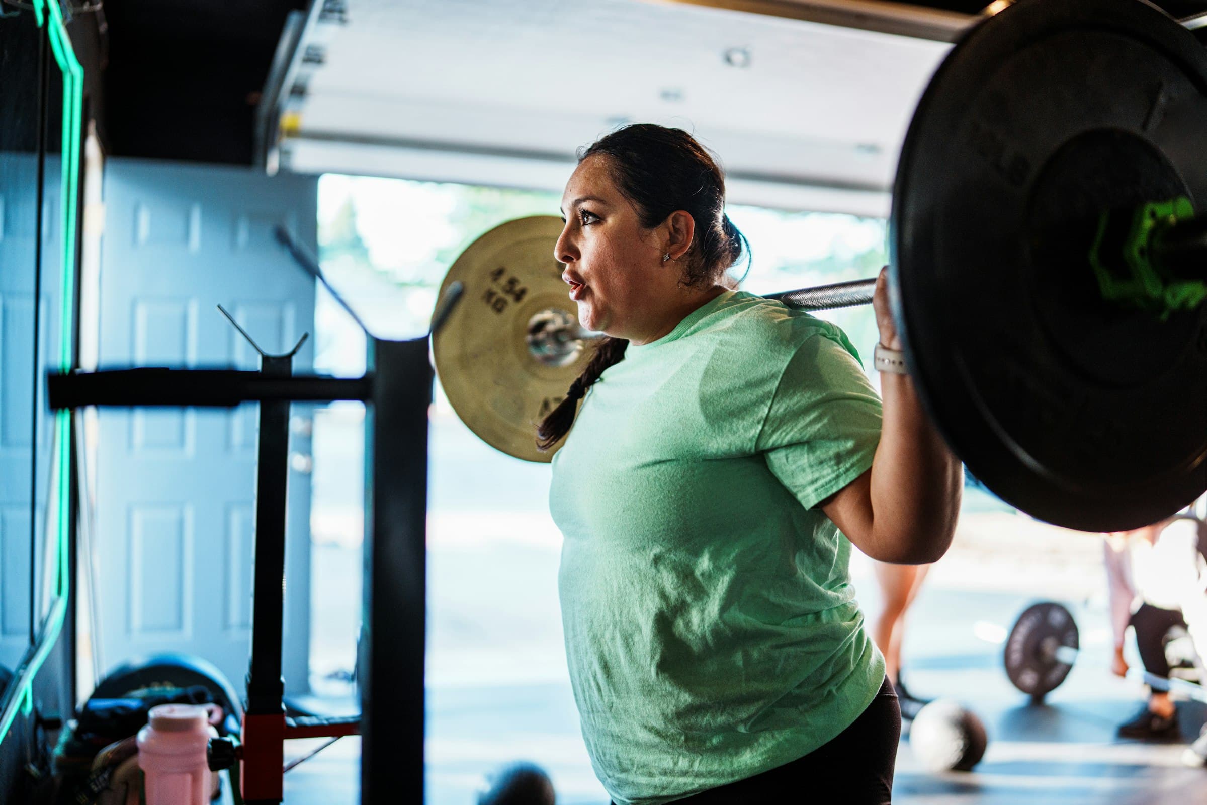 Adhérente qui s'entraîne à la barre dans un club de fitness