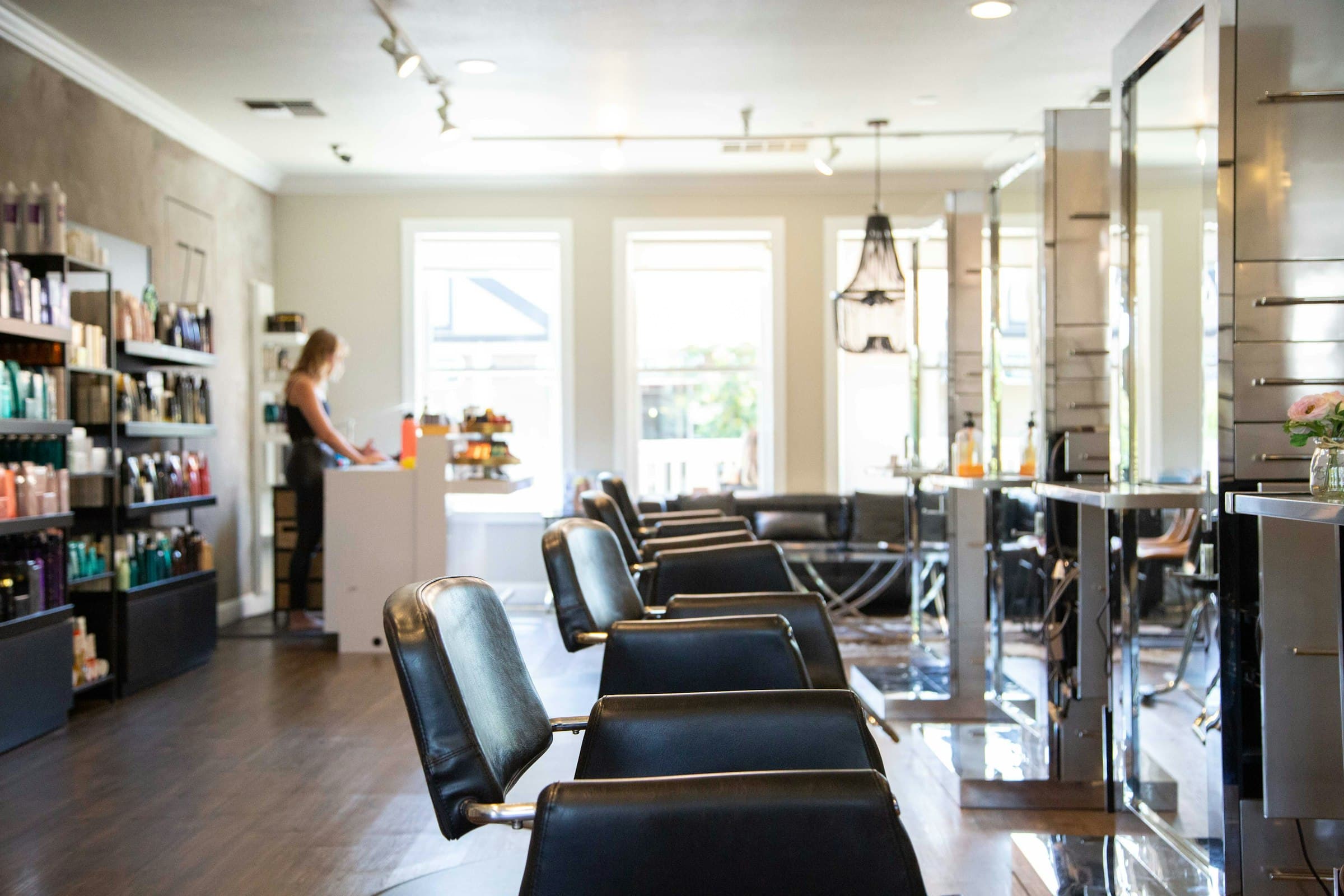 Salon de coiffure lumineux, fauteuils de cuir et miroirs alignés