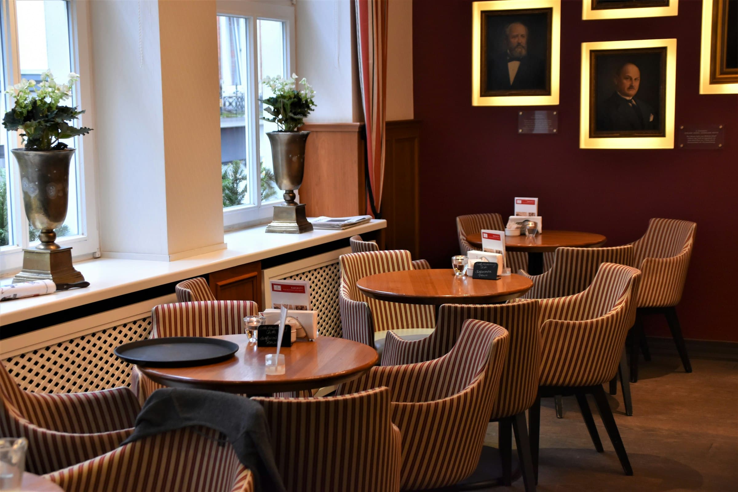 Salle de restaurant traditionnel, fauteuils rayés et tableaux encadrés