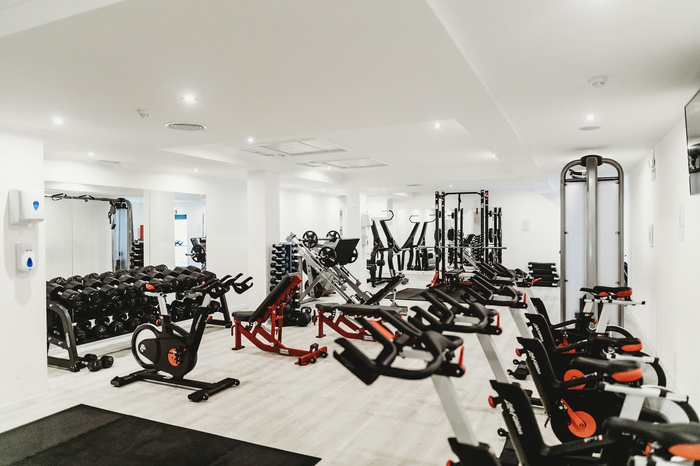 Salle de sport claire, vélos et appareils de musculation installés