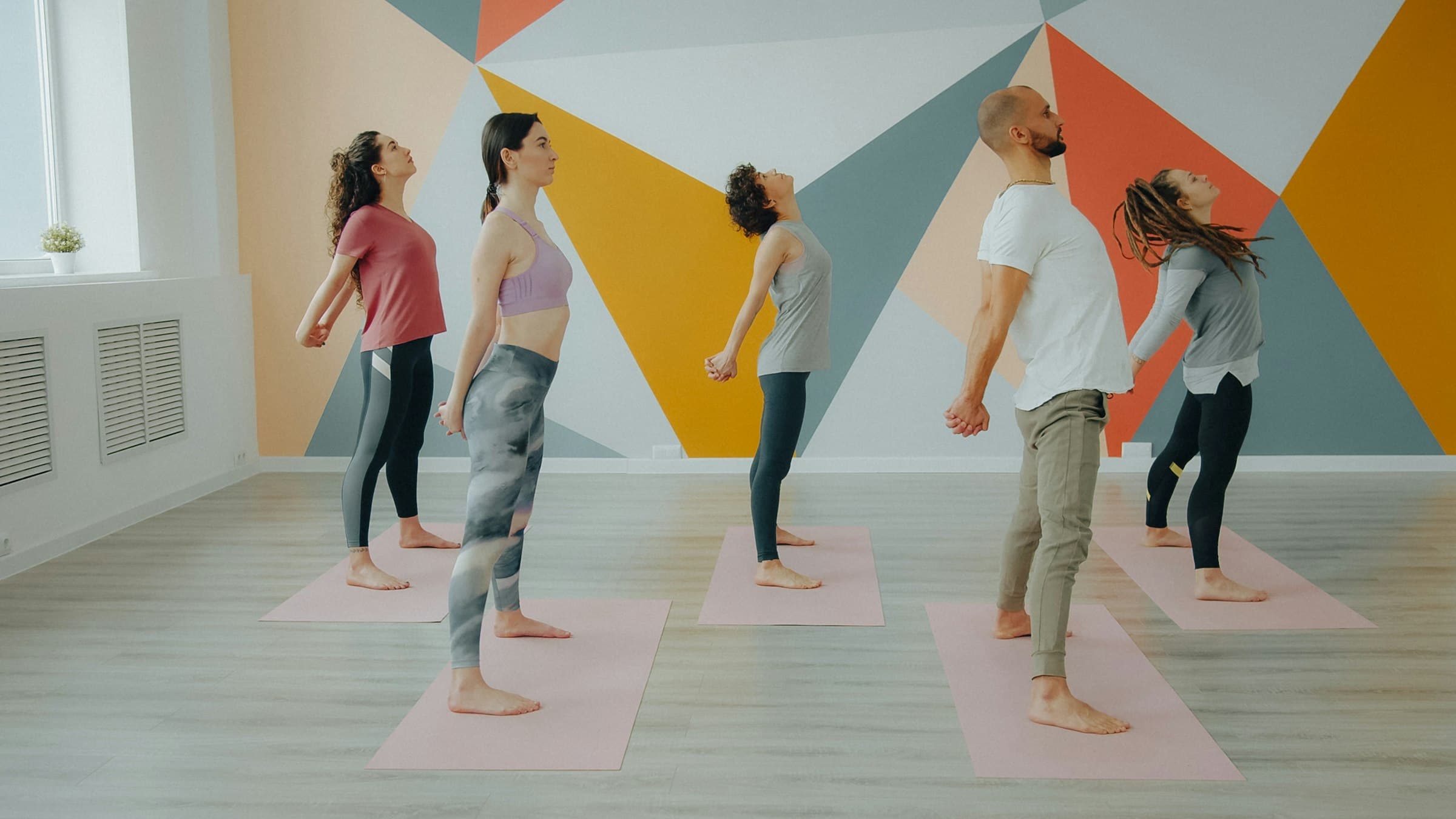 Cours de yoga collectif dans un studio aux murs colorés