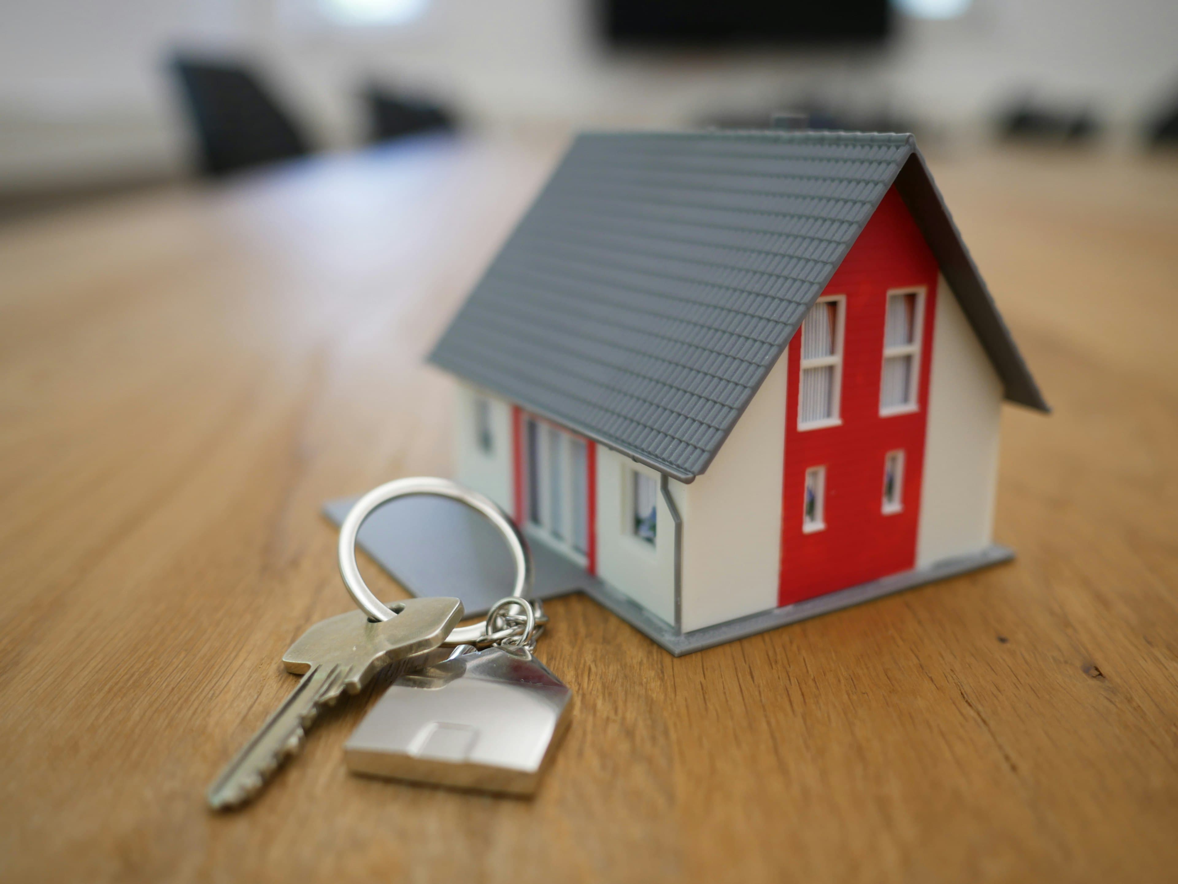 Clés posées devant une maquette de maison