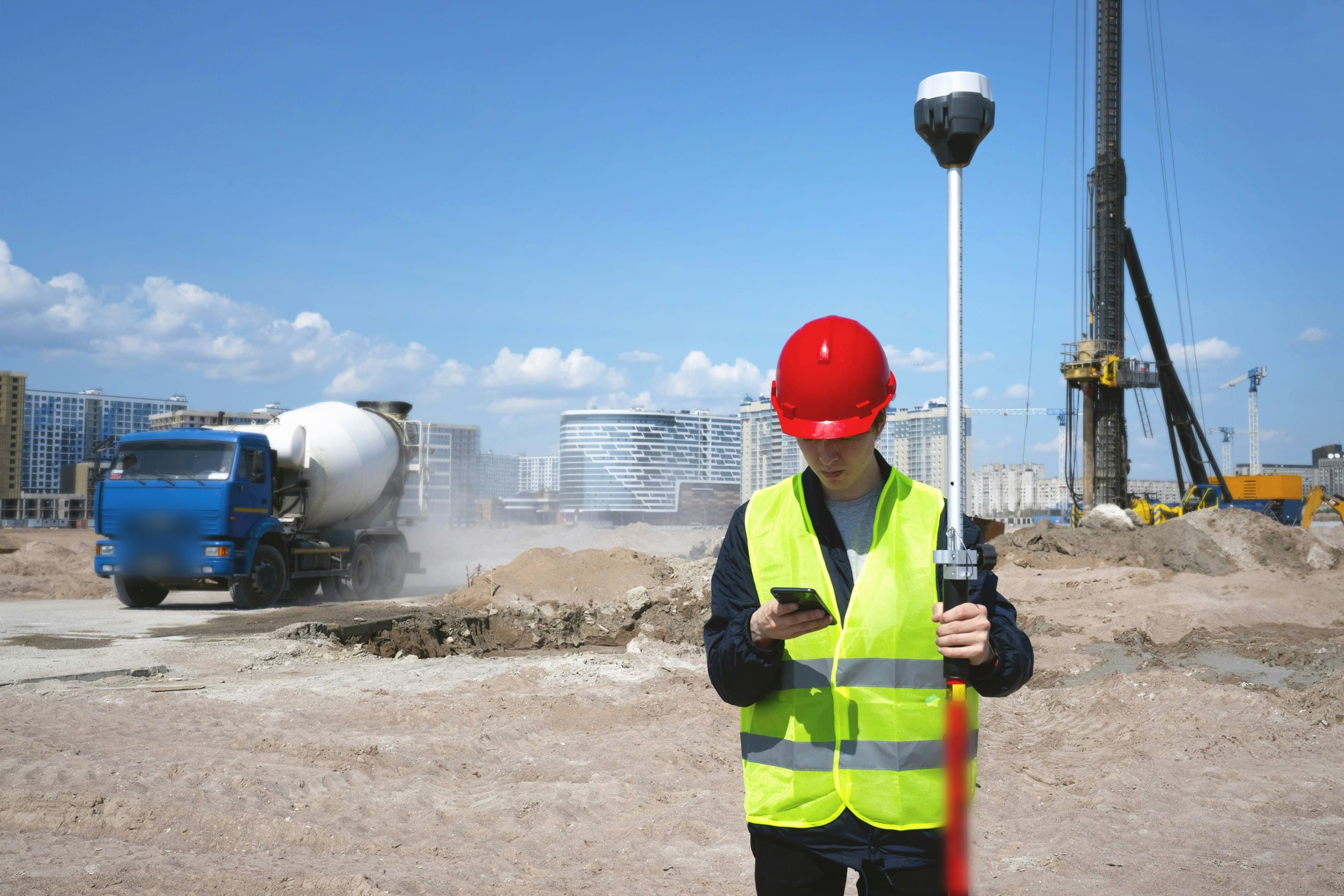 Géomètre relevant un terrain au GPS sur un site en cours d'aménagement