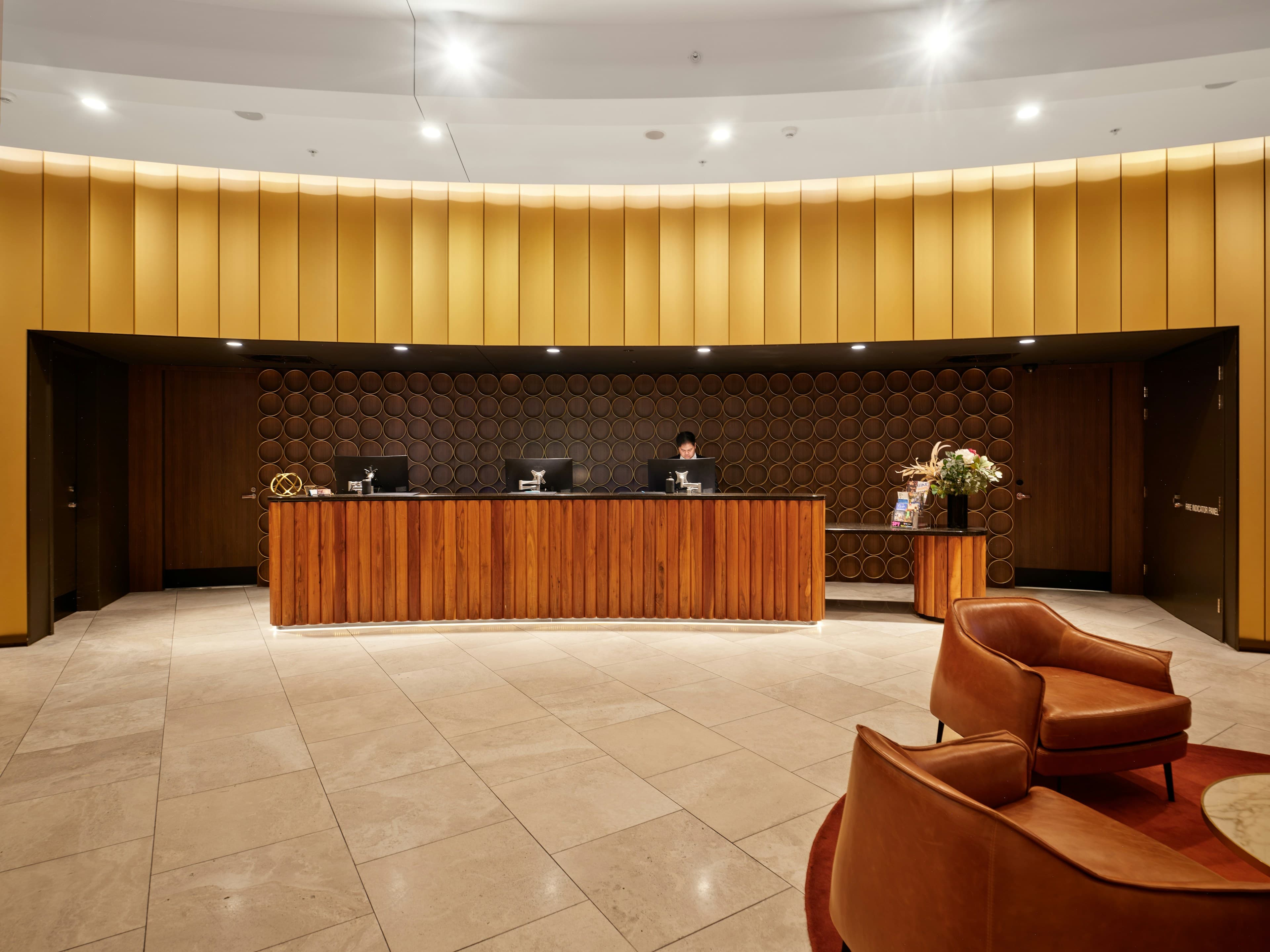 Réception d'hôtel habillée de bois, avec salon d'accueil