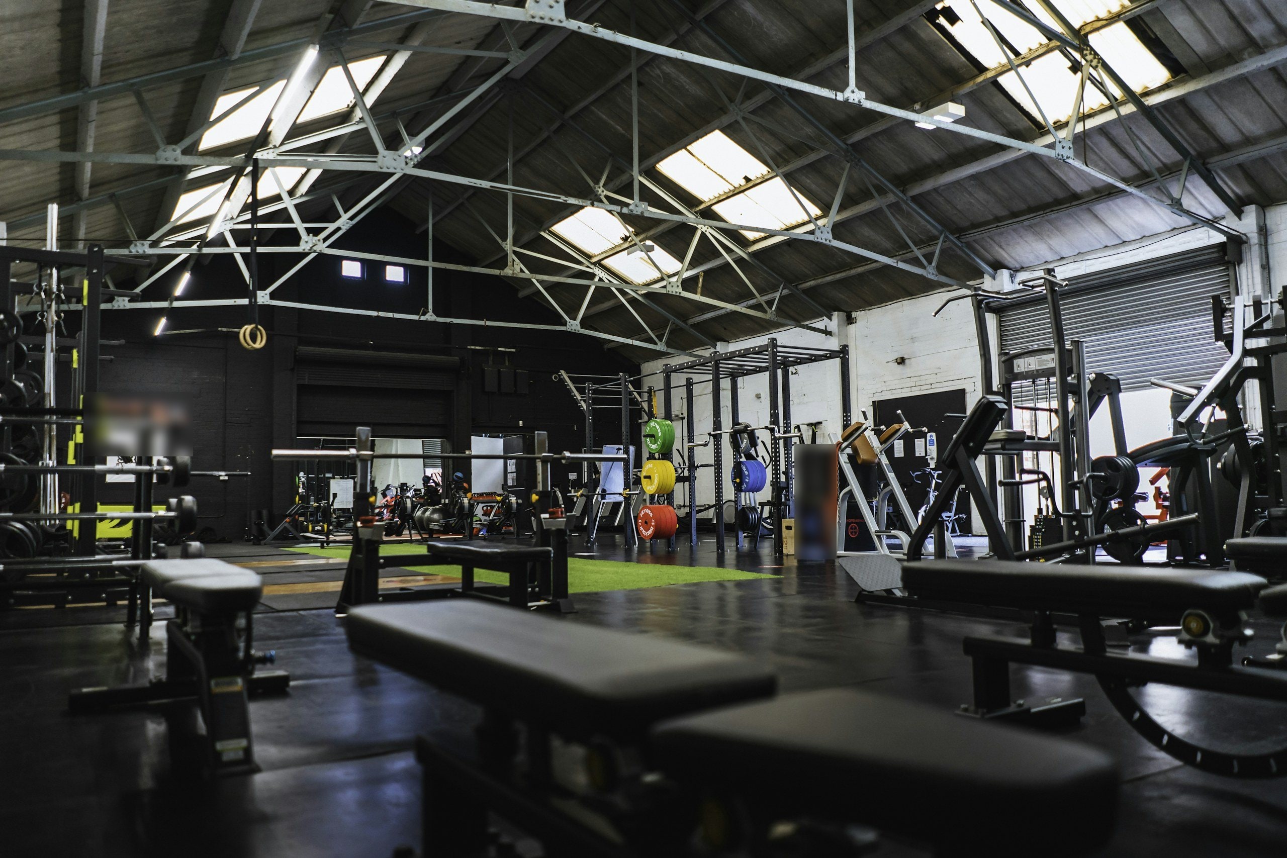 Salle de musculation dans une halle industrielle à charpente métallique et sheds vitrés