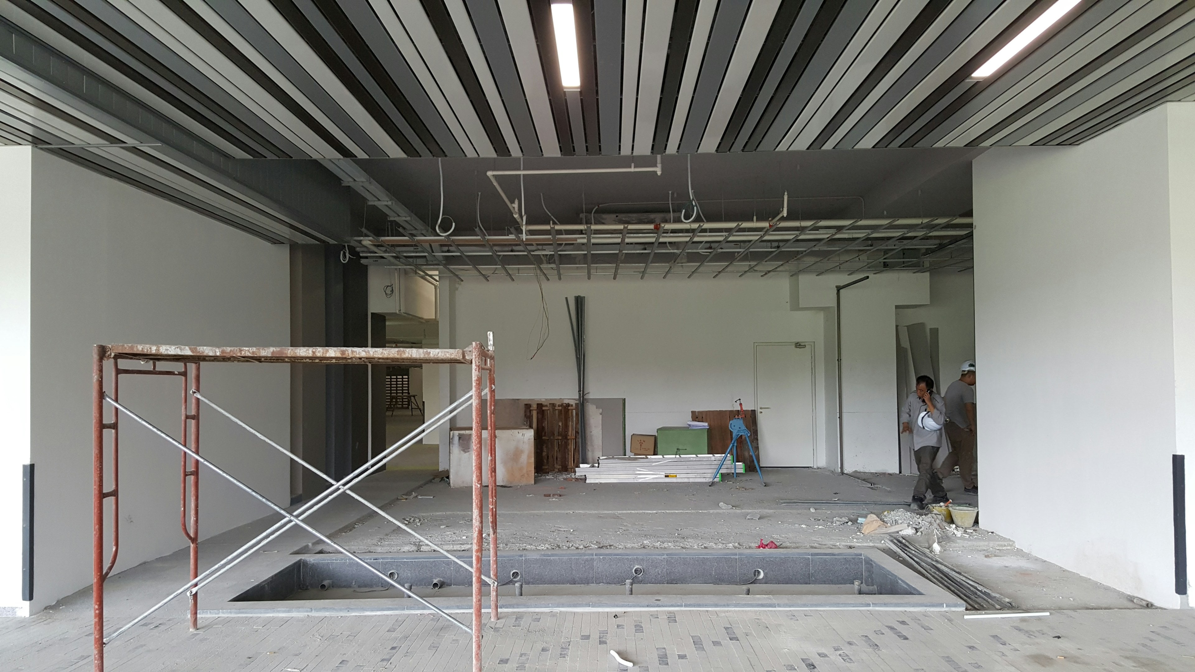 Plateau commercial en travaux, échafaudage et faux plafond en pose