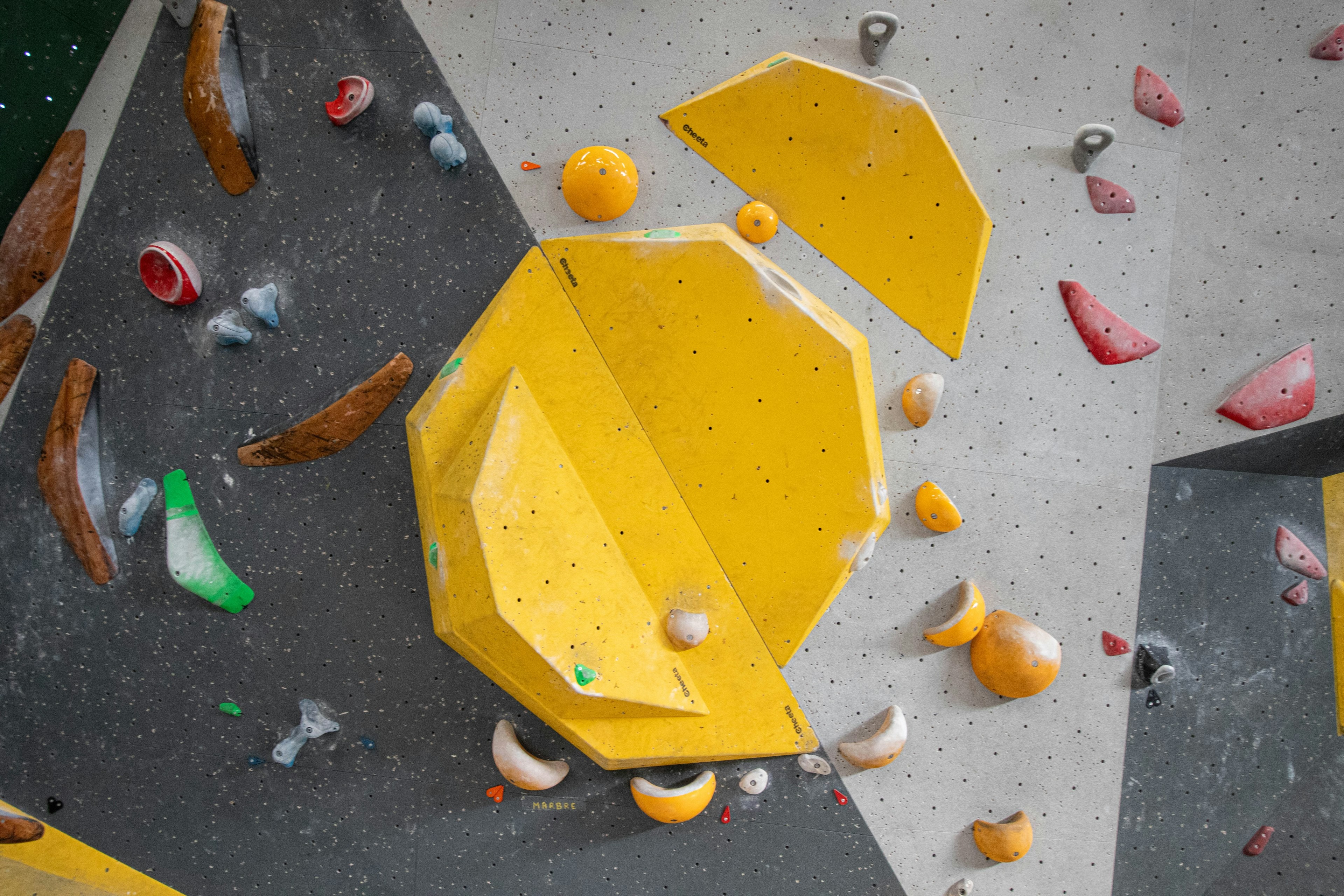 Mur de bloc d'une salle d'escalade, prises et volumes colorés