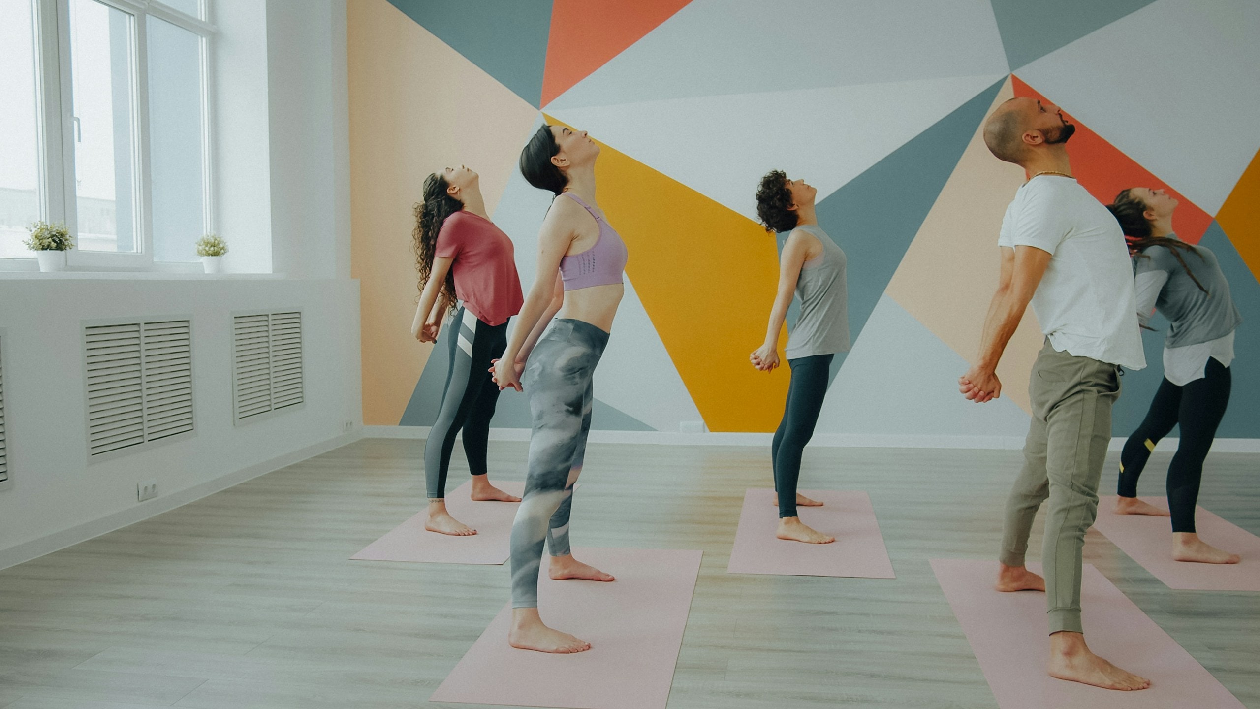 Cours de yoga dans un studio lumineux aux murs graphiques