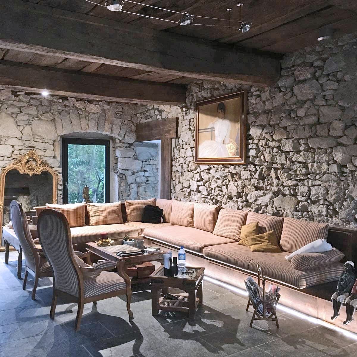 Salon aux murs de pierre et grande baie vitrée