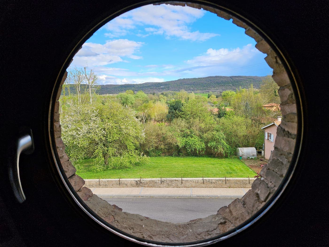 Ouverture ronde cadrant la vue sur le jardin